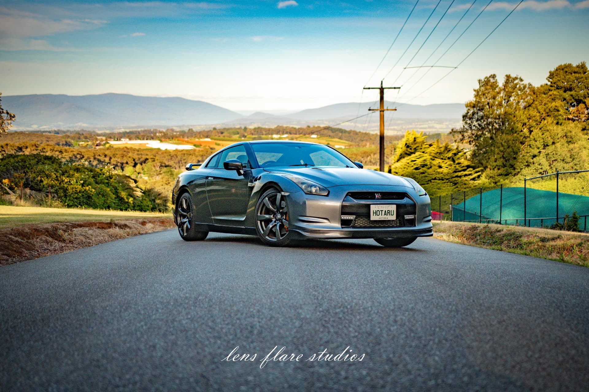 Grey sports car on a quiet country road