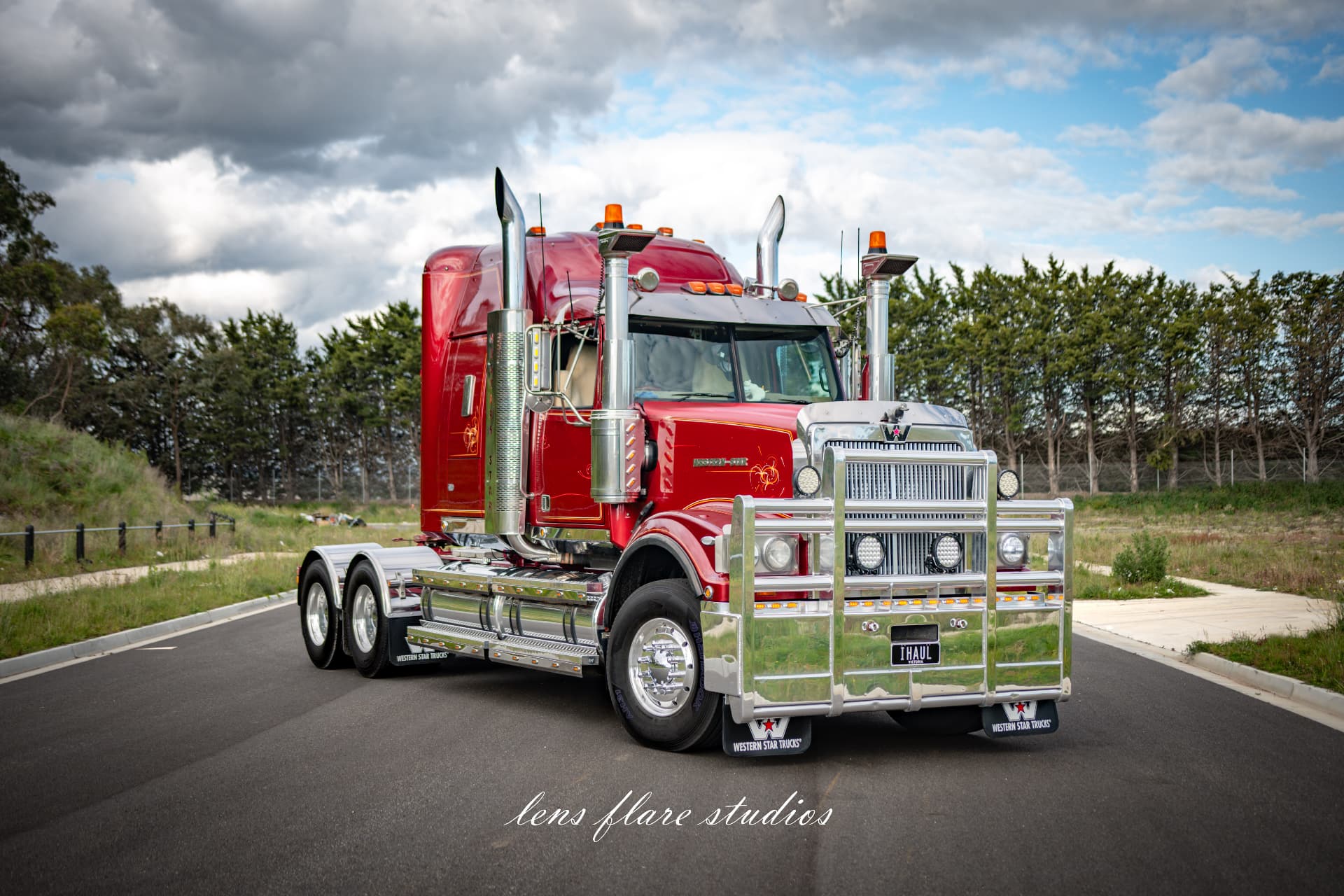 Red truck photographed under a cloudy sky