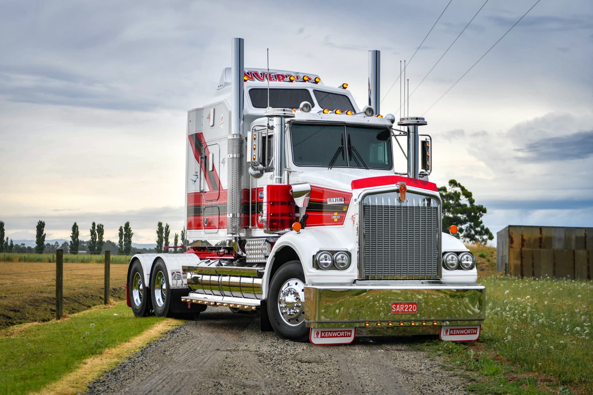 Red and white truck parked beside a country road